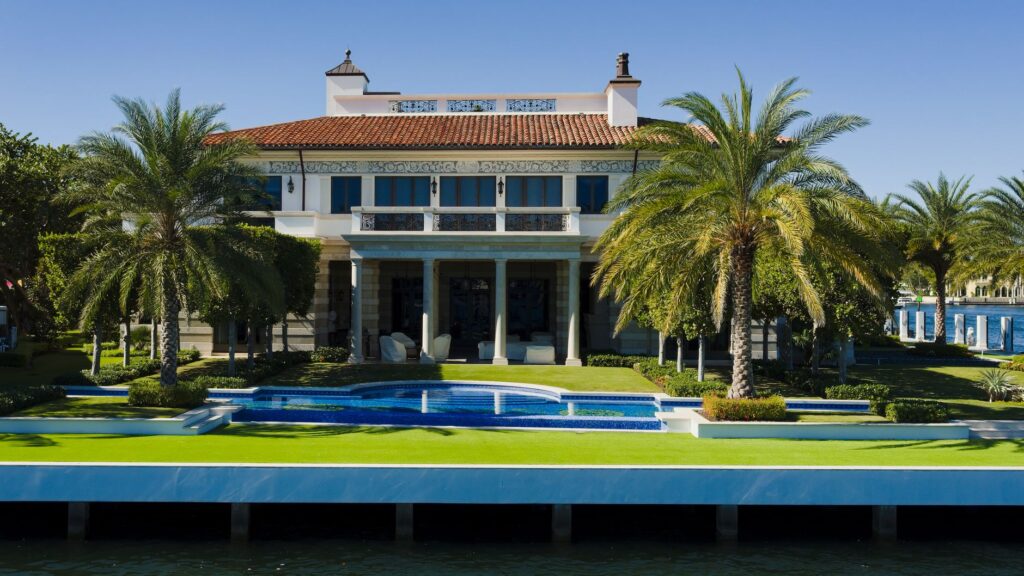 Pool terrace set above a concrete seawall at a waterfront estate