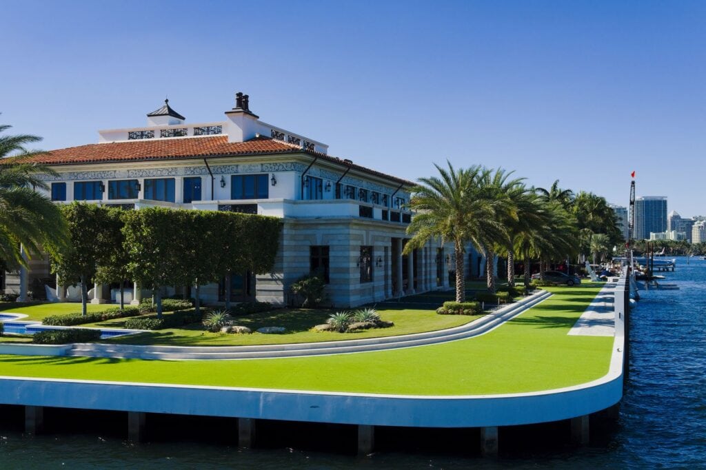 Manicured lawn running to a capped seawall at a waterfront estate