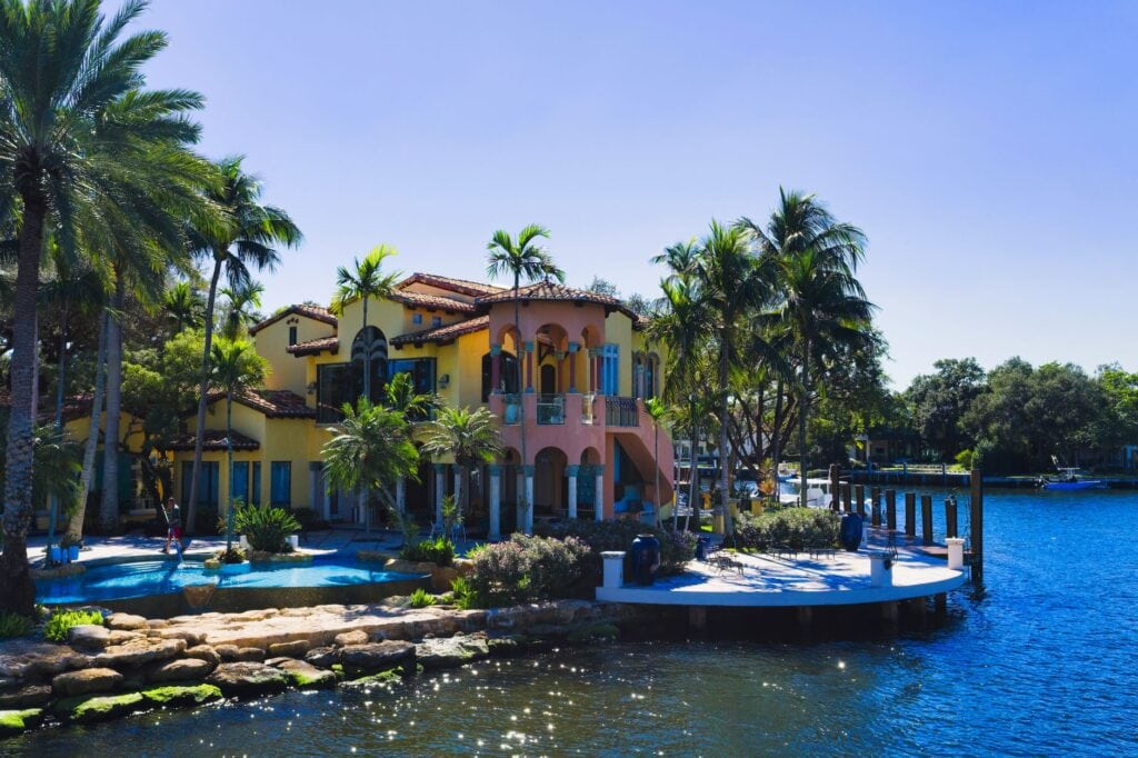 Waterfront home set among palms above a seawall
