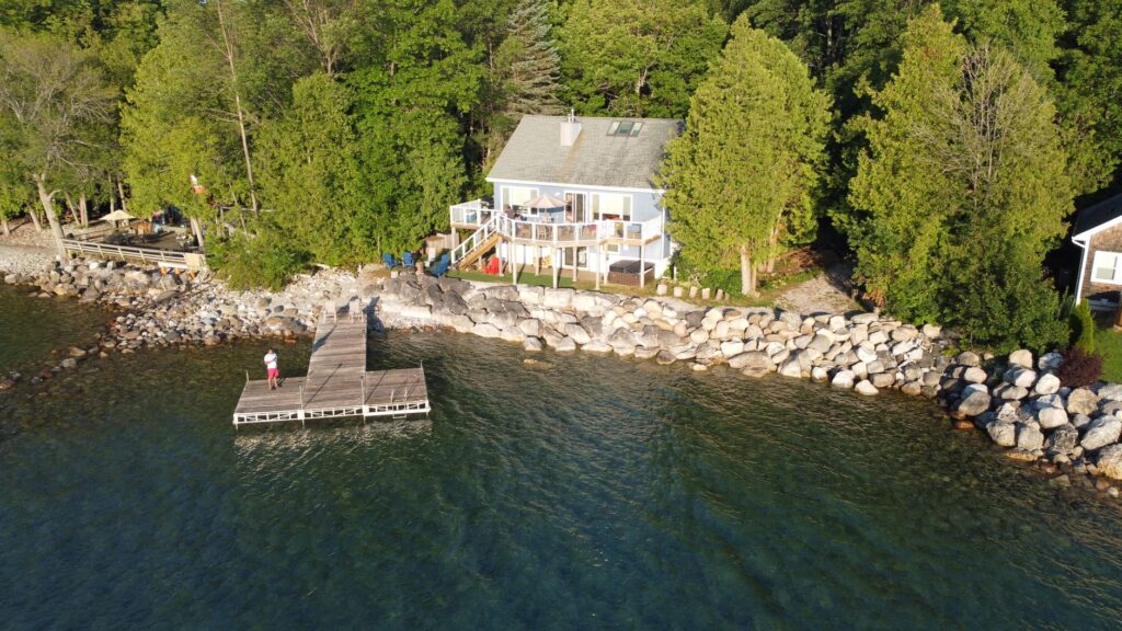 Waterfront home above a rock-armoured shoreline with a private dock