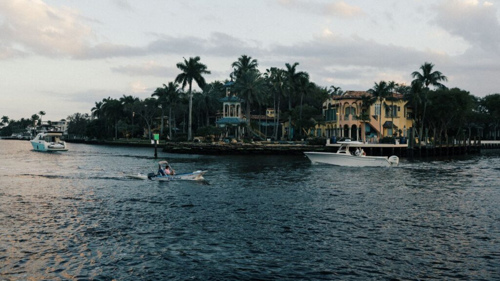 Waterfront homes and boats on a palm-lined waterway