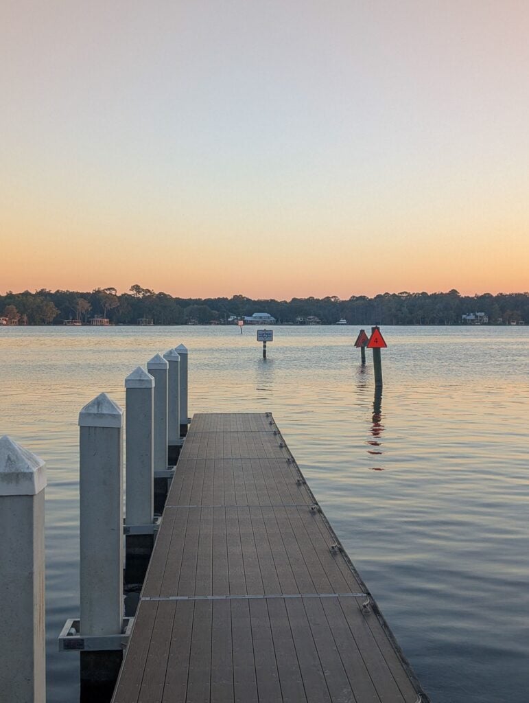Private dock reaching into calm water at sunset