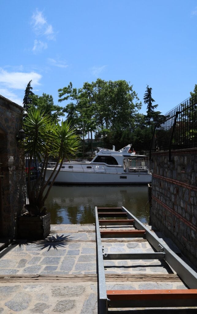 Yacht at a private dock beside a stone seawall and steps